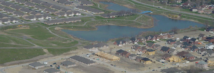 Overhead view of a subdivision and small lake