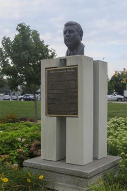 Bronze bust of Albert Howard Weeks, with a bronze plaque on a concrete plinth in a park