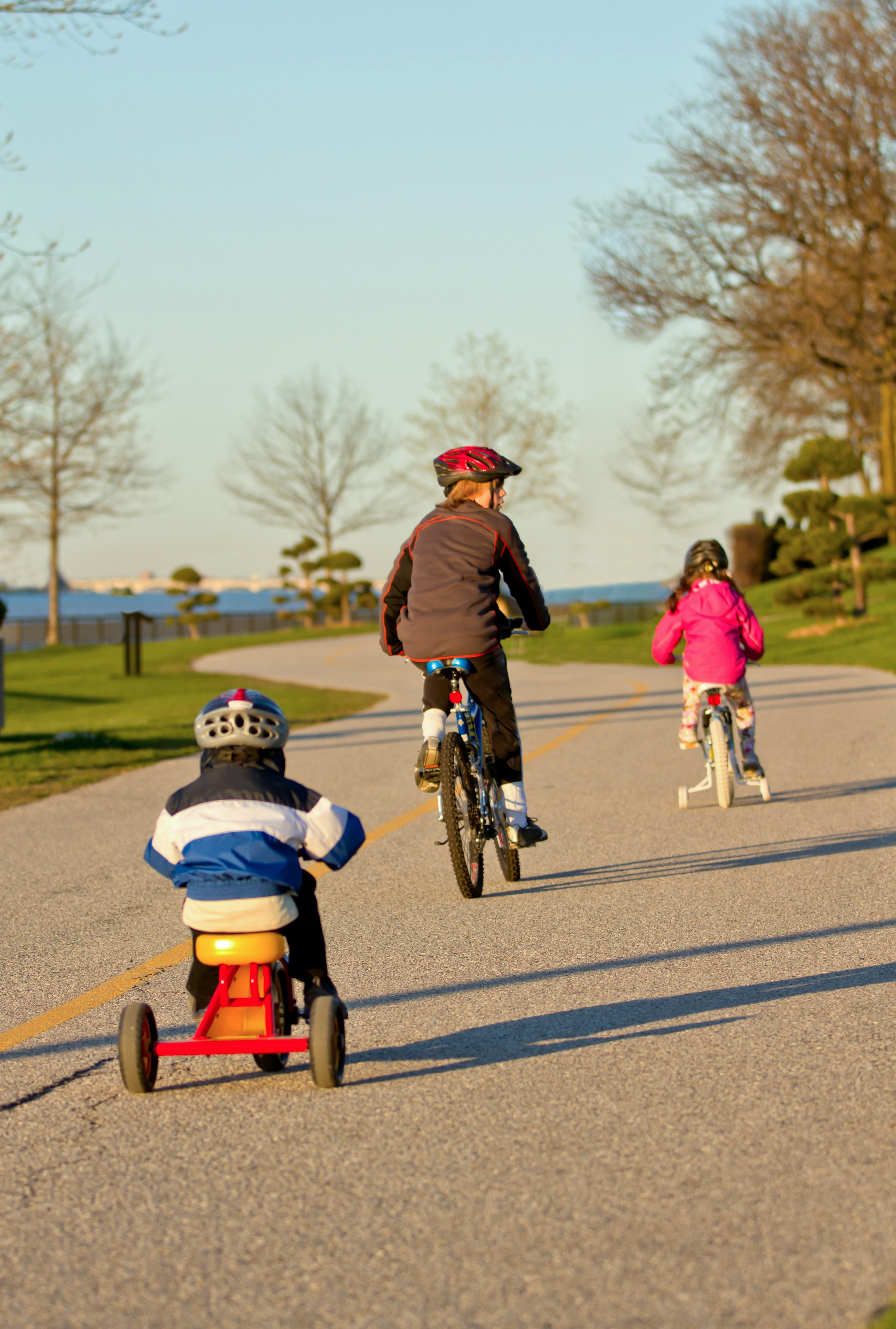 Adults and children biking along the riverfront