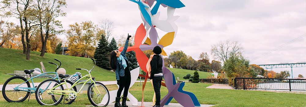 Cyclists take a break to enjoy a sculpture at the Windsor Sculpture Park