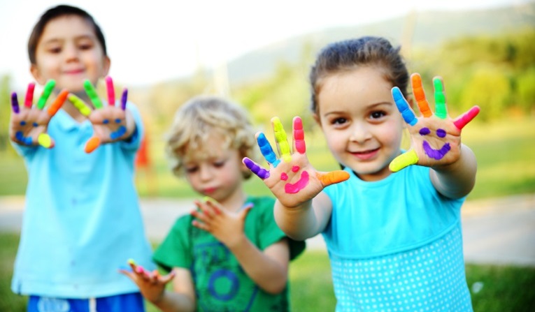 Children with happy faces painted on their hands
