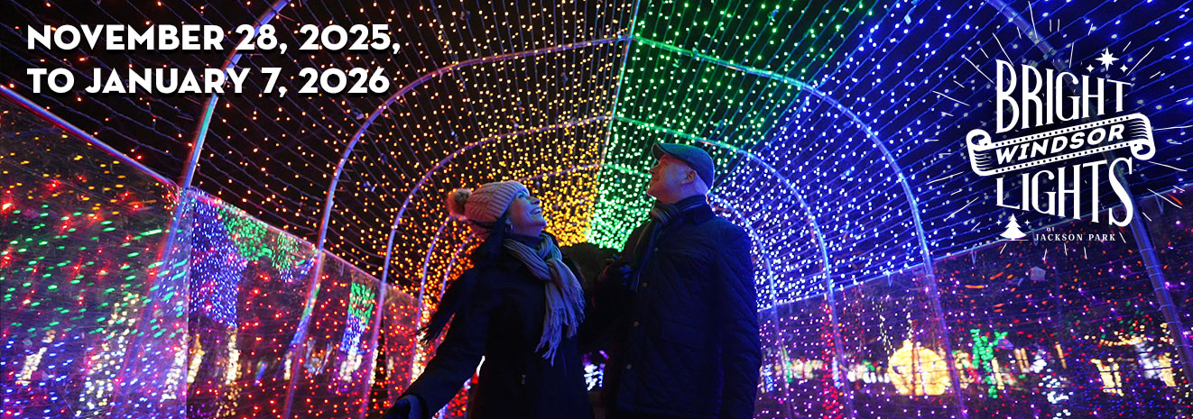 Bright Lights Windsor 2025 Marquee Couple smiling and admiring a light tunnel, logo for Bright Lights Windsor at Jackson Park, and dates November 28, 2025, to January 7, 2026