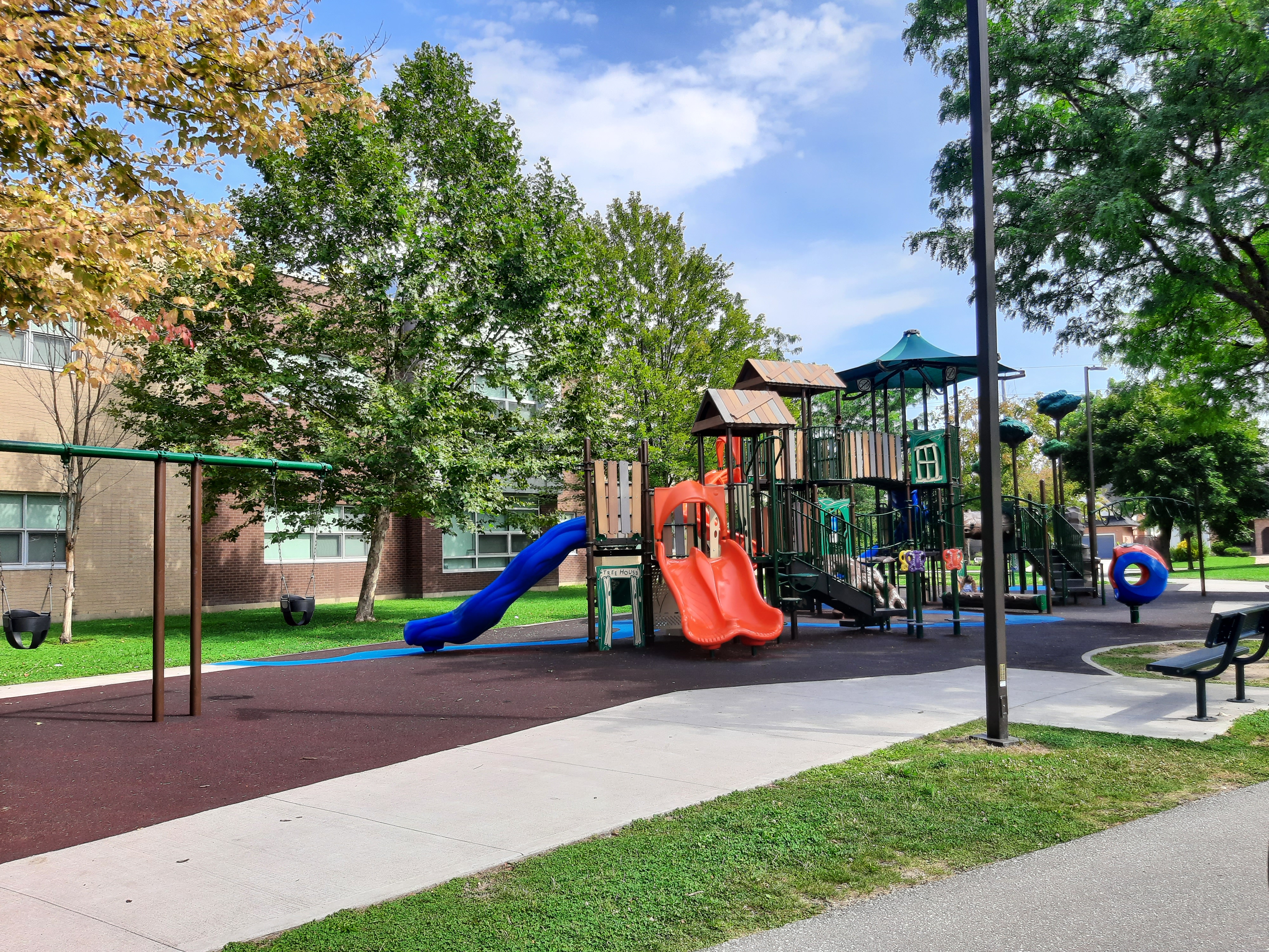 Playground equipment with trees and building in background