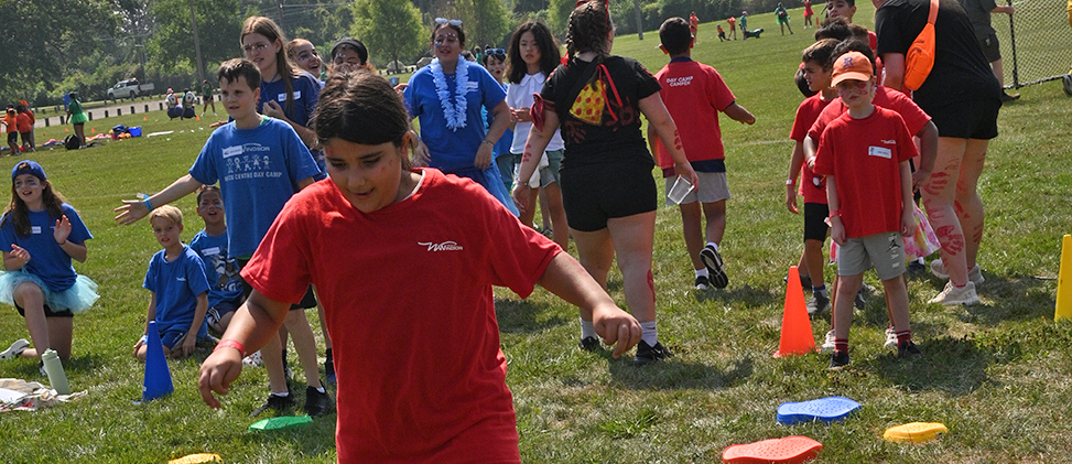 Two teams of kids cheering on an outdoor race
