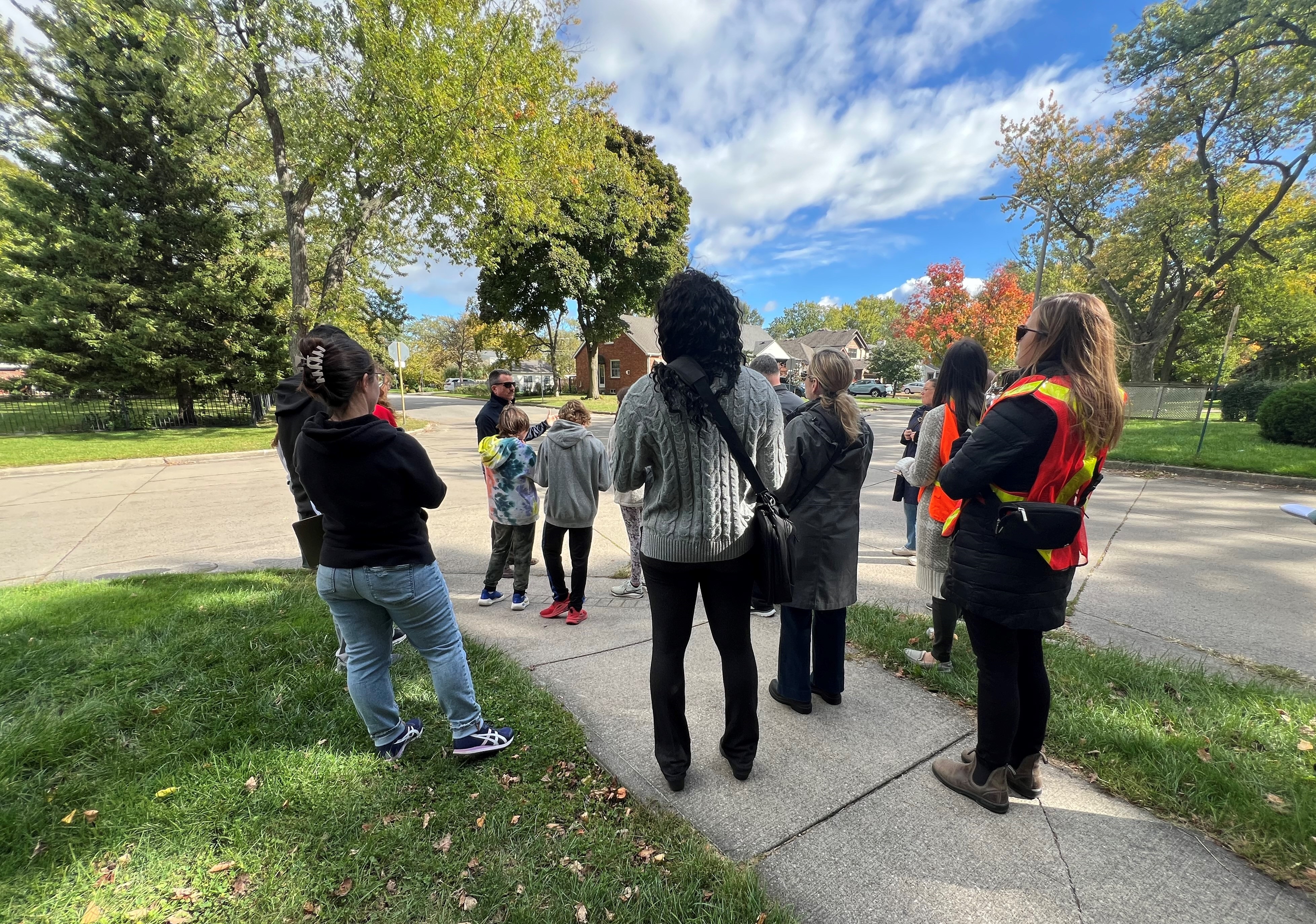 Multiple residents gathered on a sidewalk during a School Safety and Crime Prevention Audit